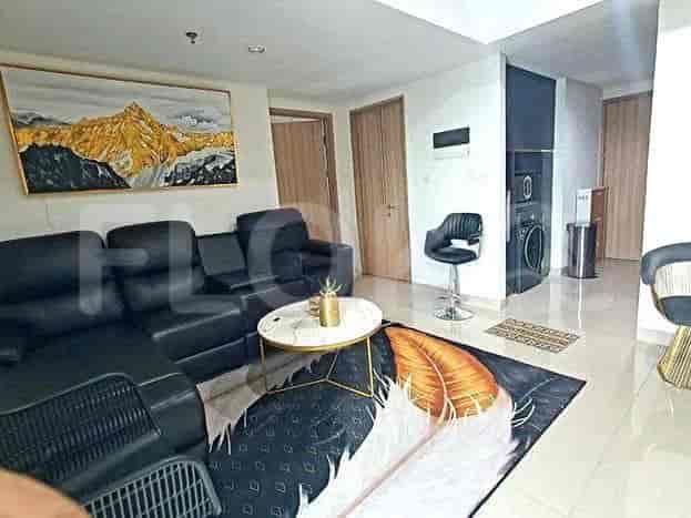 Spacious living area with a black sectional sofa, a marble-topped coffee table, and a vibrant art piece.