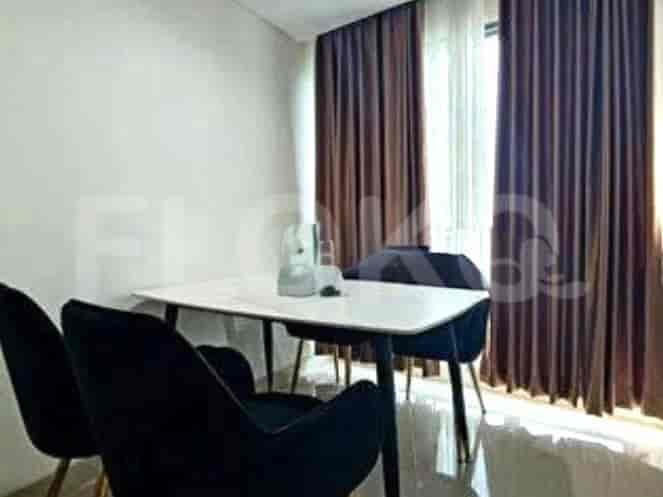 Modern dining setup with a white table and black chairs near a window with brown curtains.