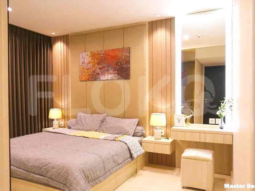 Elegant master bedroom with a bed, vanity, and warm lighting.
