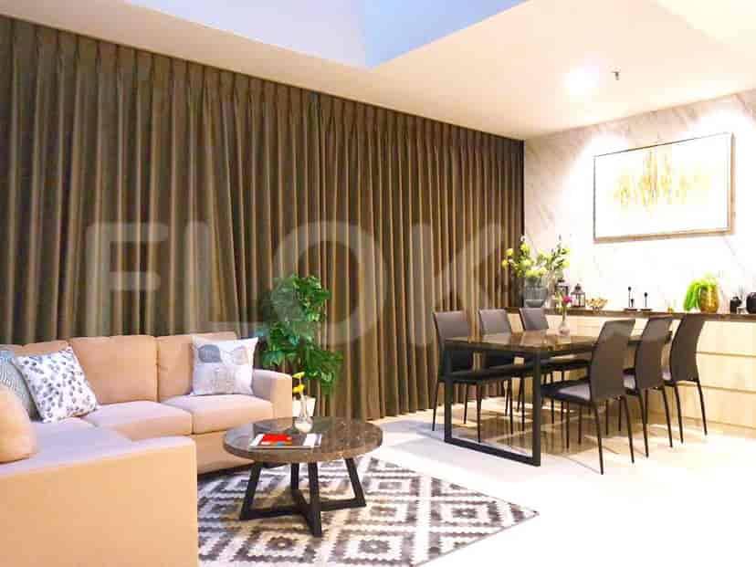 Well-lit dining and living area featuring a dining table, sofa, and decorative elements.