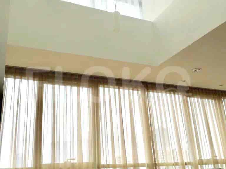 An overview of the living area, showcasing the large windows and high ceiling.