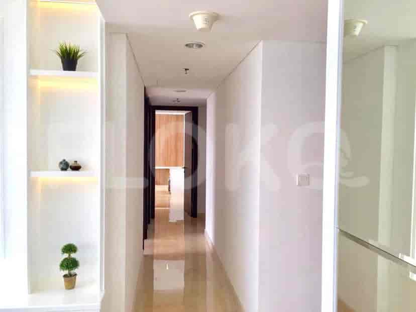 A hallway with a glossy marble floor, built-in shelving, and recessed lighting.