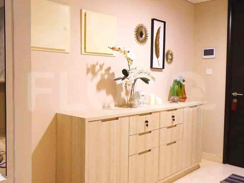 Entryway with decorative elements, including artwork, and a wooden sideboard.