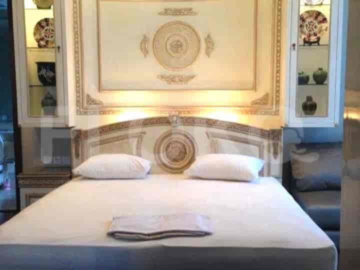 Luxurious bedroom featuring a king-sized bed with decorative headboard and built-in cabinets.