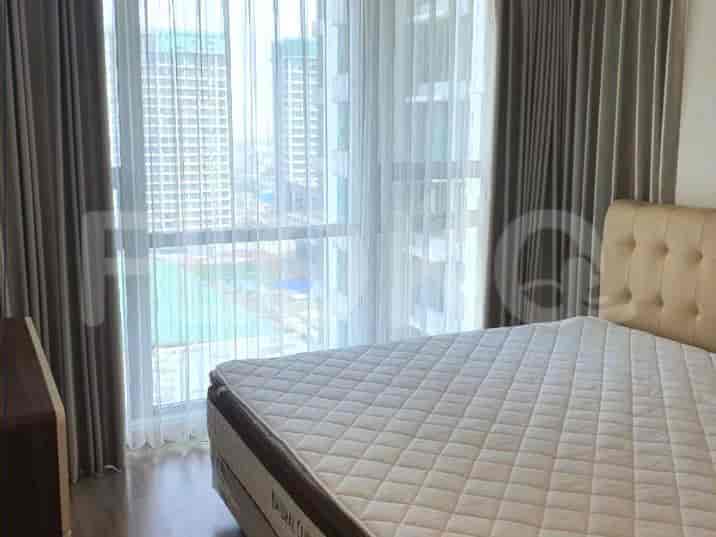 A bedroom with a queen-sized bed and large windows.