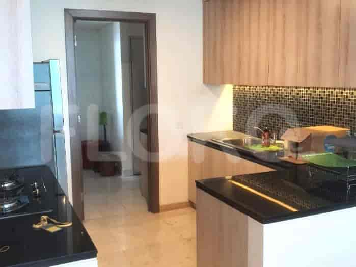 Modern kitchen with wooden cabinets and black countertops.