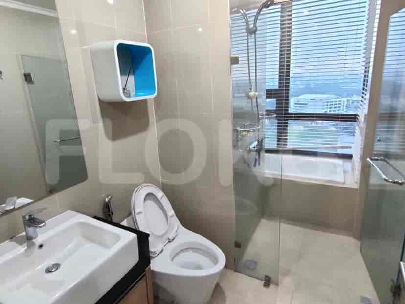 A modern bathroom with a shower area, toilet, and sink.