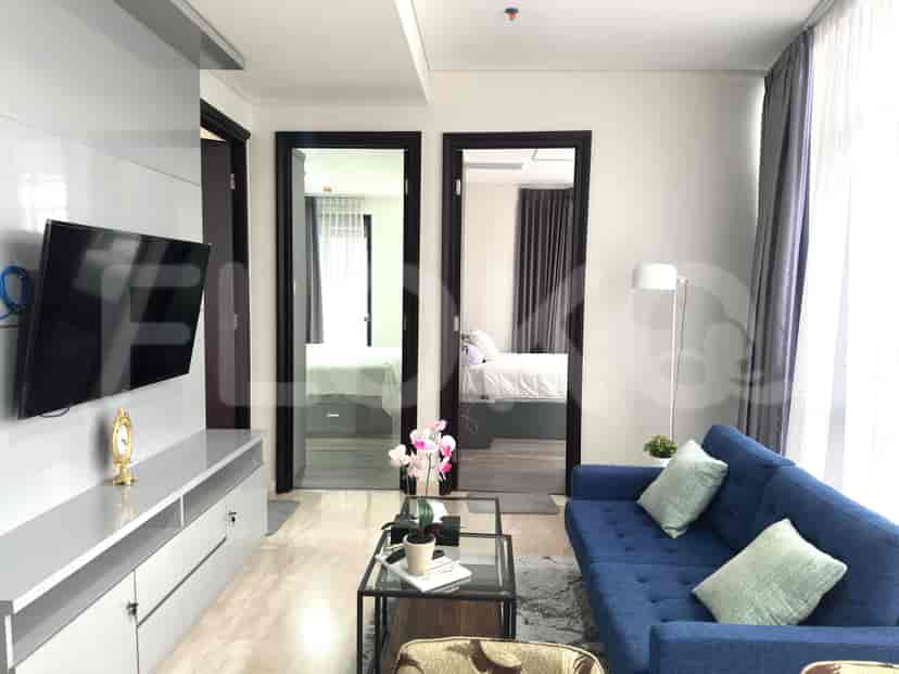 Living area with a mounted TV, sofa, and doorways to other rooms.