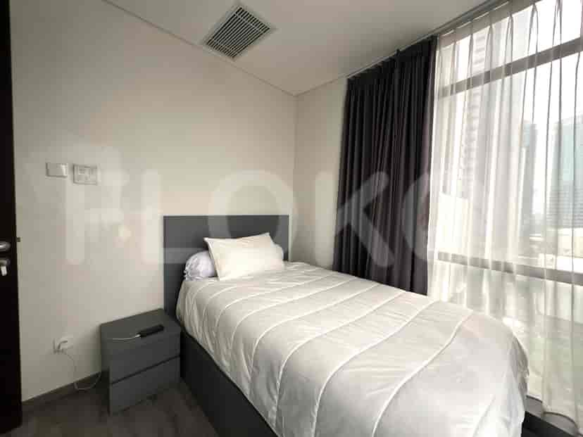 Second bedroom with a single bed and bedside table, and a view through window.