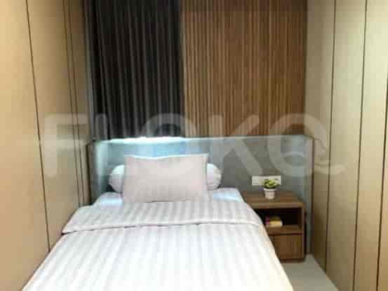 Small bedroom with a bed, nightstand, and wooden paneling.
