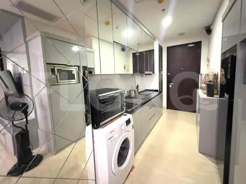 Modern kitchen with mirrored backsplash and washing machine.