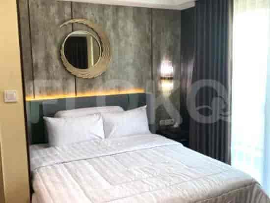 Bedroom with a bed, decorative mirror, and wall lighting.