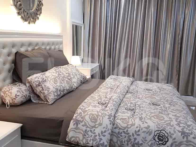 Cozy bedroom featuring a bed, mirror, and curtains.