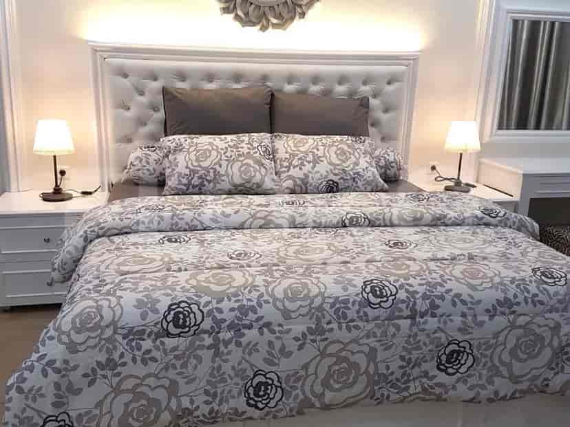 Another view of the bedroom with bed and table lamps.