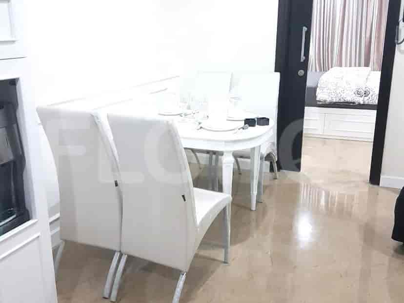 A well-lit dining area with a white oval dining table and matching chairs.