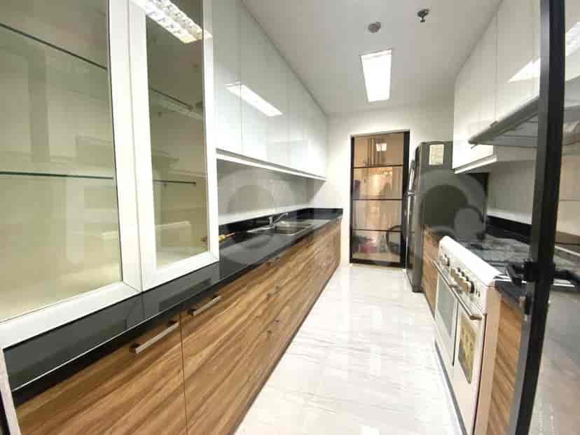 A modern kitchen with wood cabinets, a black countertop, and stainless steel appliances.