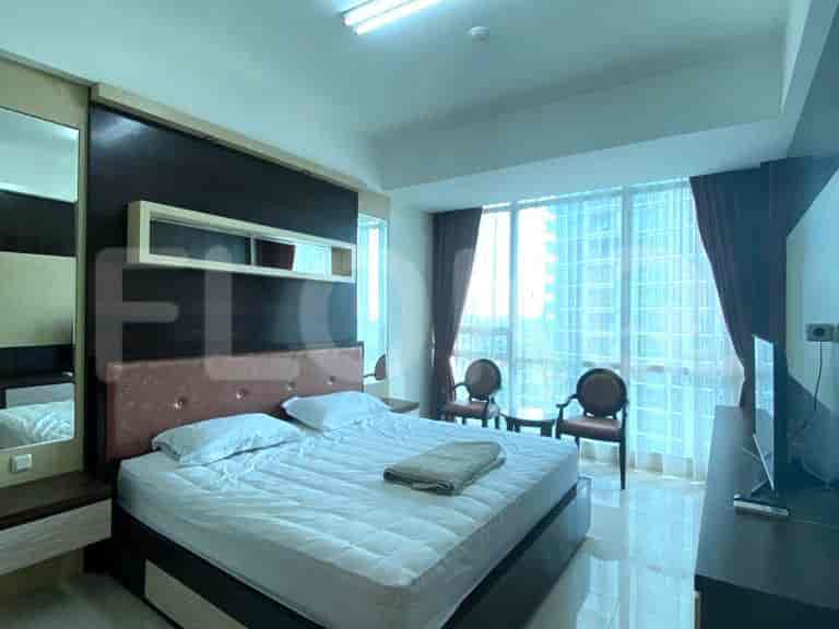 A bedroom with a double bed, mirror, and window.