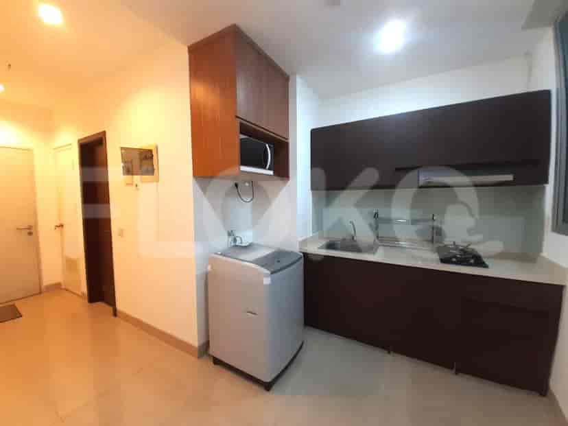 A modern kitchen with wooden cabinetry, a washing machine, and a stove.