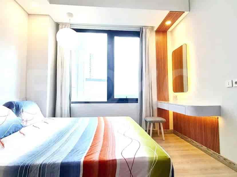 Kamar tidur modern yang menampilkan jendela besar, tempat tidur ganda, dan panel kayu.