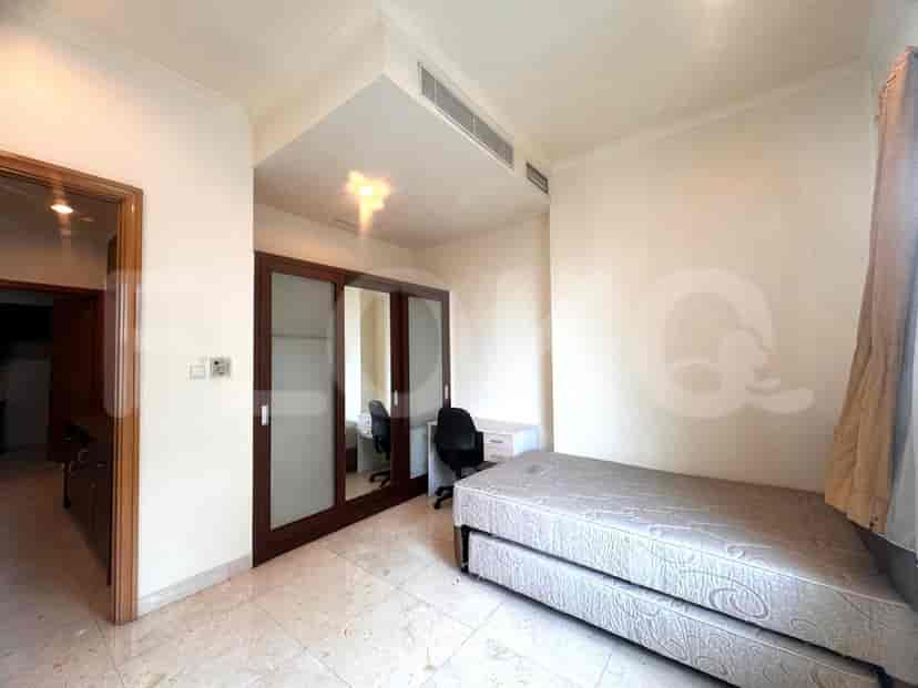 A bedroom with a bed and study area.