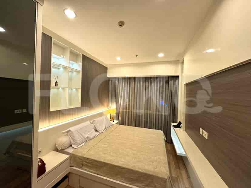 Kamar tidur dengan tempat tidur besar, meja samping tempat tidur, dan jendela.