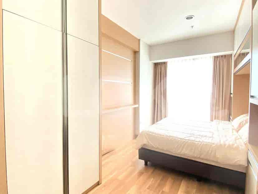 Bedroom with a bed, a large window, and built-in closet.