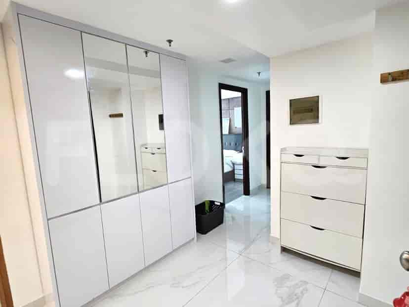 A hallway with a closet and shoe rack.