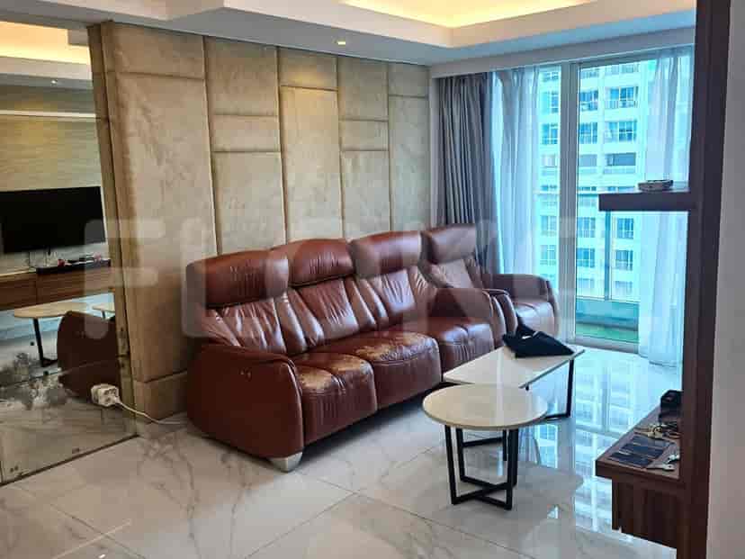 Living room with brown leather sofa, marble floor and a large mirror.