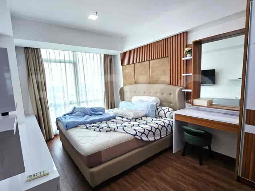 Bedroom with a bed, a desk, and a large window.