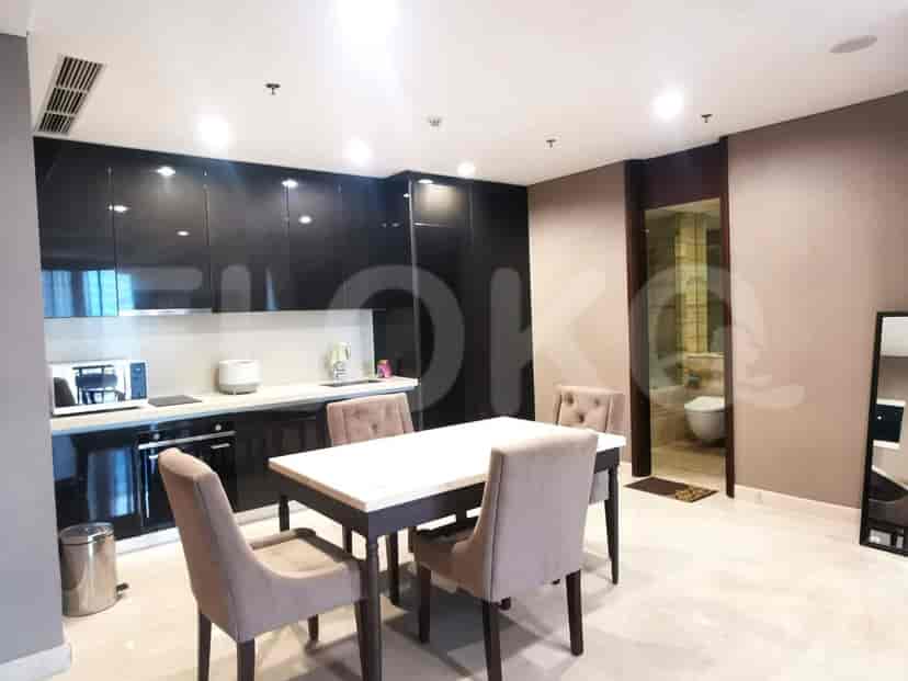 A modern kitchen with dark cabinets, along with a dining area.