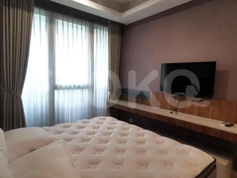 The bedroom with a large bed and TV, showcasing its modern design.
