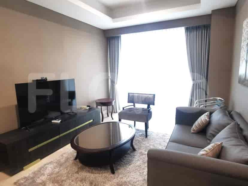 A modern living room with a large TV, comfortable seating, and elegant decor.
