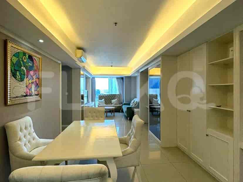 Dining area adjacent to the living room with a white table and chairs, and an art piece.