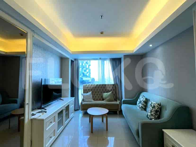 A bright and airy living room with a light blue sofa, a tufted sofa, a white coffee table, and a TV console.