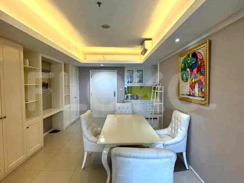 Dining area with a view of the kitchen, featuring white cabinetry and a vibrant green backsplash.