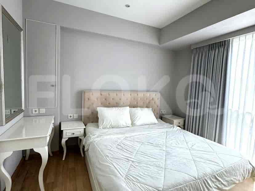 A well-lit bedroom with a bed, vanity, and a view.