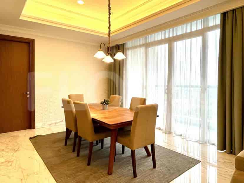 Area makan dengan meja kayu dan enam kursi.