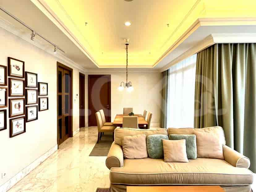 Ruang tamu dengan sofa, meja makan, dan seni dinding.