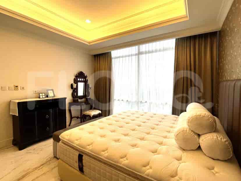 Kamar tidur dengan tempat tidur, meja rias, dan furnitur kayu gelap.
