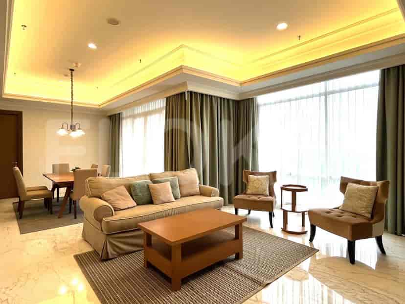 Ruang tamu dengan sofa krem, meja kopi kayu, dan area makan.