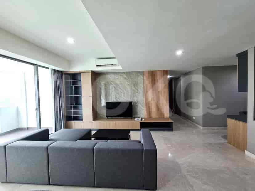 Ruang tamu modern dengan sofa berbentuk L, TV, dan pemandangan kota.