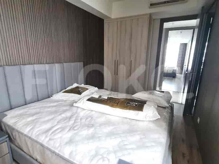 Kamar tidur dengan tempat tidur, lemari pakaian, dan pemandangan ke ruangan lain.