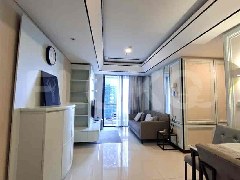 A modern living room with a grey sofa, a large window, and stylish white cabinetry.