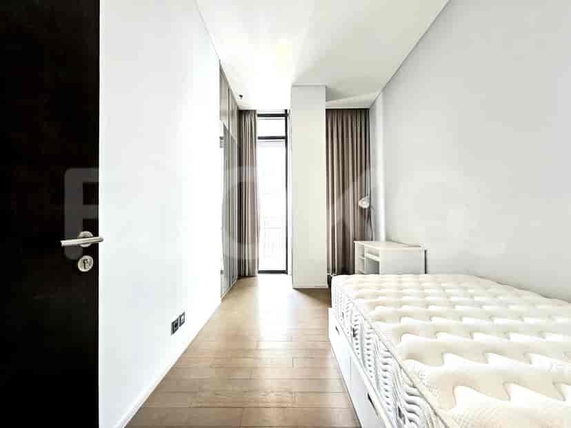 Bedroom hallway with a single bed and a desk.