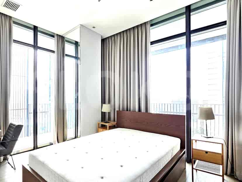 Bedroom with a bed, nightstands, and floor-to-ceiling windows.