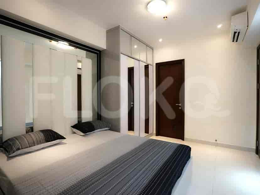 A modern bedroom with a mirrored wall, built-in closet, and comfortable bed.
