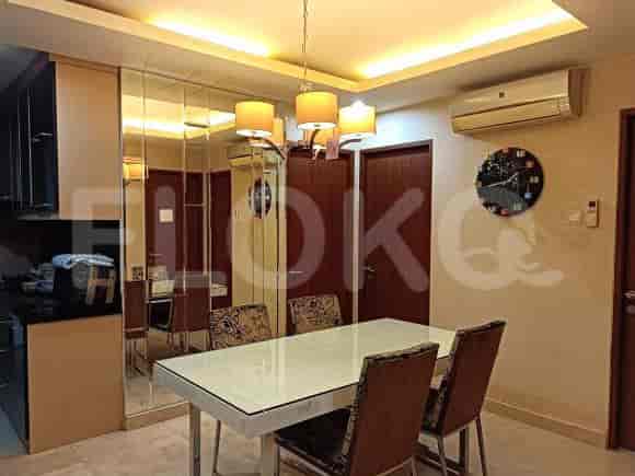 Dining area with a table and chairs, mirror, and chandelier.