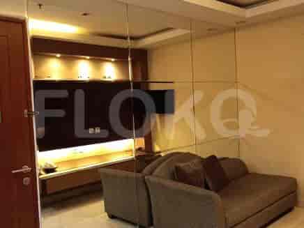 Living room featuring a brown sofa, mirror panels, and TV.
