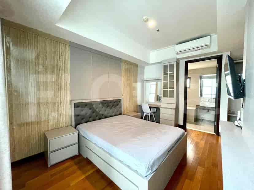 Master bedroom featuring a large bed, built-in storage, and a desk.