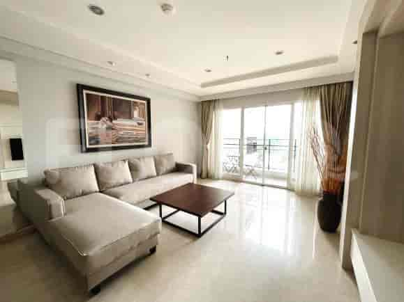 Modern living room with a beige L-shaped sofa, framed artwork, and a square coffee table.